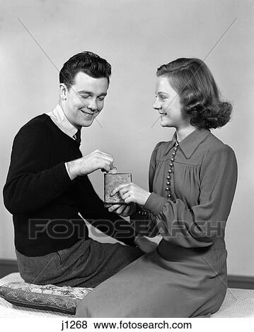 1940S Young Teen Couple Girl Holding Small Bank Boy Dropping In Coin View Large Photo Image Stock Photo - 1940S Young Teen Couple Girl Holding Small Bank Boy Dropping In Coin . Fotosearch