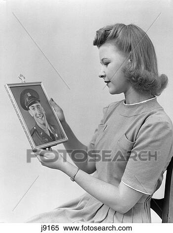 1940S Young Woman Teen Girl Holding Framed Photo Of Man In Military Uniform View Large Photo Image Stock Photography - 1940S Young Woman Teen Girl Holding Framed Photo Of Man In Military Uniform . Fotosearch