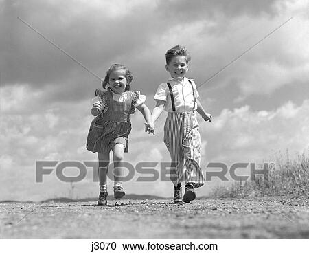 1950S 1940S Boy Girl Holding Hands Running Down Dirt Road Clouds Sky Behind Happy Smiling Couple Friends Friendship Romance View Large Photo Image Stock Image - 1950S 1940S Boy Girl Holding Hands Running Down Dirt Road Clouds Sky Behind Happy Smiling Couple Friends Friendship Romance. Fotosearch