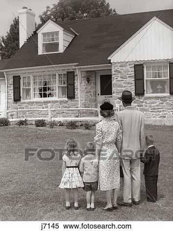Stock Photography - 1950S Family Of 5 With Backs To Camera On Lawn Looking At Flagstone House . Fotosearch
