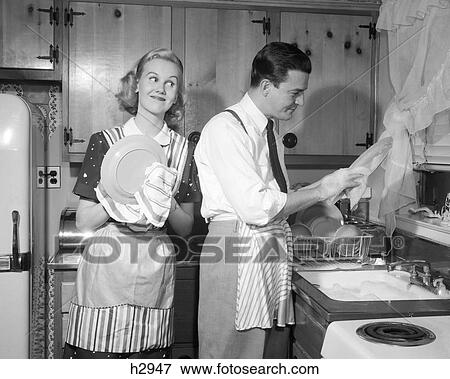 Stock Photo - 1950S Husband And Wife Drying Dishes In Kitchen . Fotosearch
