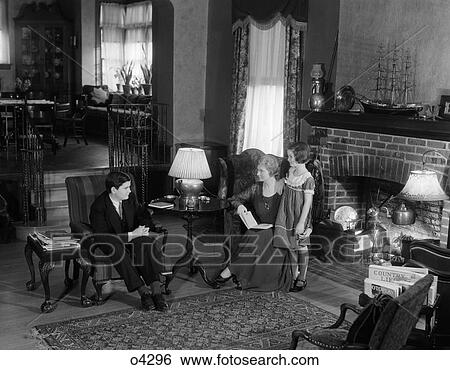 Stock Photograph - Family Indoors Livingroom Study Sitting Chairs Child Daughter Book Social Talk Fireplace Rug . Fotosearch