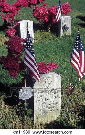 Stock Image - Medal Of Honon Winner Grave Site Cemetary War Flags Flowers Headstone. Fotosearch