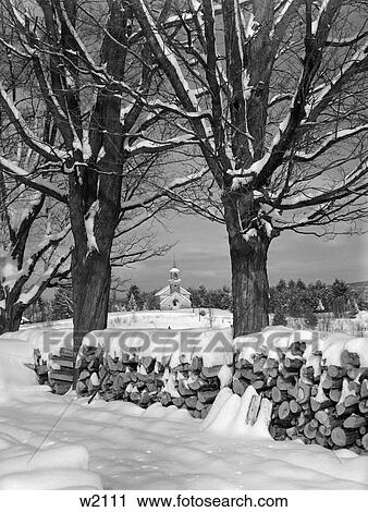 Pile Of Snow-Covered Logs Between Two Trees With Country Church In Background View Large Photo Image Stock Image - Pile Of Snow-Covered Logs Between Two Trees With Country Church In Background . Fotosearch
