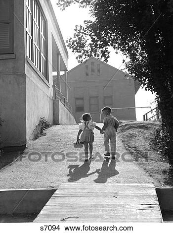 Two School Children Boy And Girl Walking To School Holding Hands 1940S 1950S View Large Photo Image Picture - Two School Children Boy And Girl Walking To School Holding Hands 1940S 1950S. Fotosearch