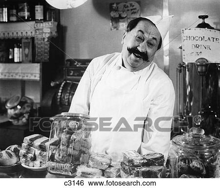 Stock Photograph - Vintage Portrait Of Smiling Proprietor Behind Counter In General Store . Fotosearch