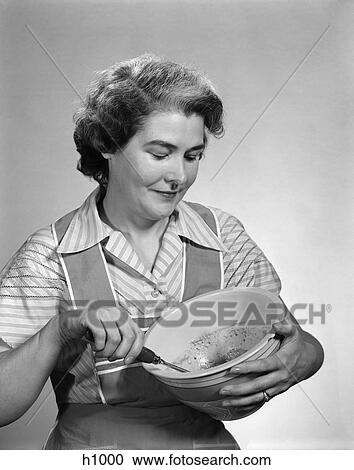 Stock Image - Woman Baking Cooking Mixing Bowl Apron 1940S Retro. Fotosearch