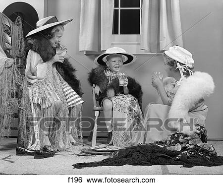Stock Photograph - 1950 1950S Boy & Two Girls Wearing Adult Clothes Smiling And Holding Glasses Of Milk Playing Dress Up . Fotosearch