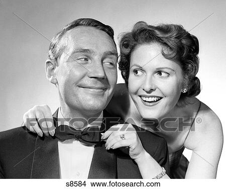 1950 1950S Couple Dressed In Formal Attire Woman Pulling On Man'S Bowtie View Large Photo Image Picture - 1950 1950S Couple Dressed In Formal Attire Woman Pulling On Man'S Bowtie . Fotosearch