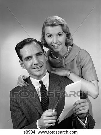 1950 1950S Couple Smiling Man Holding Pen Paper View Large Photo Image Picture - 1950 1950S Couple Smiling Man Holding Pen Paper . Fotosearch