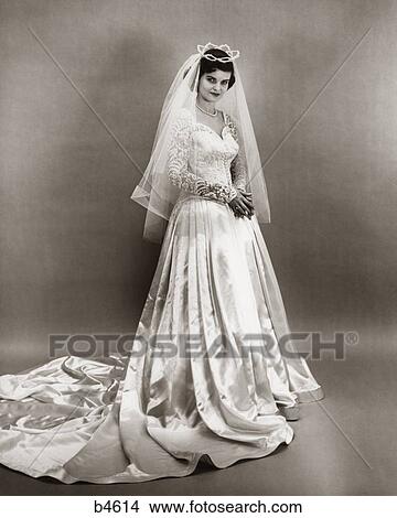 Picture - 1950 1950S Full Length Portrait Bride Standing Wearing Wedding Gown Veil Tiara Headpiece . Fotosearch