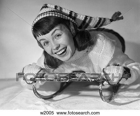 Stock Photography - 1950 1950S Girl Posing On Sled In Winter Clothes In Studio . Fotosearch