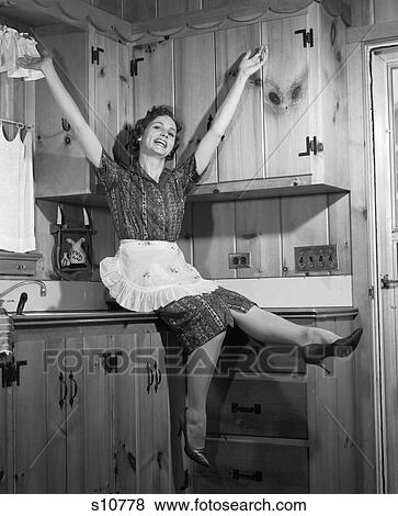 1950 1950S Housewife Sitting On Countertop Kicking Feet Arms In Air View Large Photo Image Stock Photo - 1950 1950S Housewife Sitting On Countertop Kicking Feet Arms In Air . Fotosearch