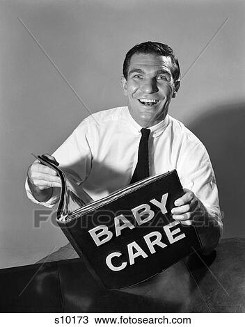 Stock Image - 1950 1950S Man Holding Baby Care Book . Fotosearch