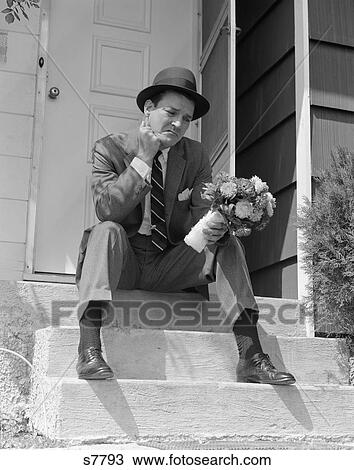 1950 1950S Man In Suit Holding Flowers Sitting Outside Front Door On Steps Looking Sad View Large Photo Image Stock Image - 1950 1950S Man In Suit Holding Flowers Sitting Outside Front Door On Steps Looking Sad . Fotosearch
