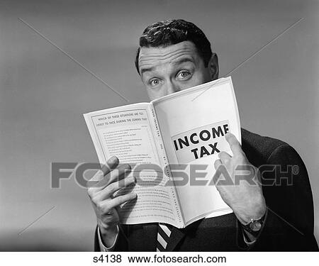 Stock Photo - 1950 1950S Man In Suit Nose In Income Tax Book . Fotosearch