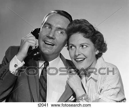 1950 1950S Man On Telephone Woman Leaning In Listening Both Smiling View Large Photo Image Stock Image - 1950 1950S Man On Telephone Woman Leaning In Listening Both Smiling . Fotosearch