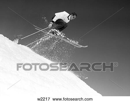 1950 1950S Man Skier Skiing Down Slope Jumping Into Air Mid-Air Men Skiers Ski Skis Skiing Winter Sports View Large Photo Image Stock Photo - 1950 1950S Man Skier Skiing Down Slope Jumping Into Air Mid-Air Men Skiers Ski Skis Skiing Winter Sports. Fotosearch
