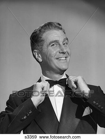 Stock Photo - 1950 1950S Man Smiling In Tuxedo Pulling On His Bow Tie . Fotosearch