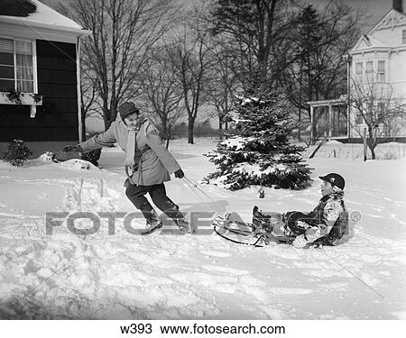 1950 1950S Mother Pulling Son In Sled In Winter View Large Photo Image Stock Image - 1950 1950S Mother Pulling Son In Sled In Winter . Fotosearch