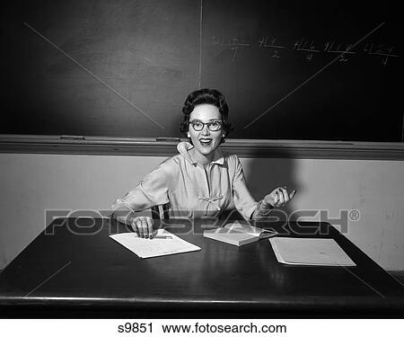 1950 1950S School Teacher Wearing Glasses Sitting At Desk In Front Of Board In Classroom View Large Photo Image Stock Image - 1950 1950S School Teacher Wearing Glasses Sitting At Desk In Front Of Board In Classroom . Fotosearch