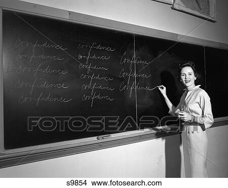 1950 1950S Teacher In Front Of Classroom Writing Confidence On Board View Large Photo Image Picture - 1950 1950S Teacher In Front Of Classroom Writing Confidence On Board . Fotosearch