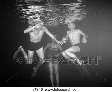 Stock Photograph - 1950 1950S View Of Three Swimmers Under Water . Fotosearch