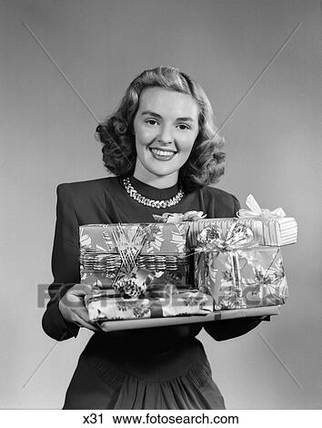 1950 1950S Woman Holding Pile Of Wrapped Gifts Smiling At Camera View Large Photo Image Stock Image - 1950 1950S Woman Holding Pile Of Wrapped Gifts Smiling At Camera . Fotosearch