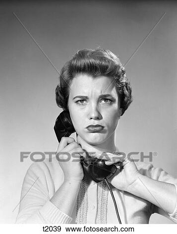 1950 1950S Woman Holding Receiver Hand Over Receiver Looking At Camera With Annoyed Angry Expression View Large Photo Image Stock Photo - 1950 1950S Woman Holding Receiver Hand Over Receiver Looking At Camera With Annoyed Angry Expression . Fotosearch