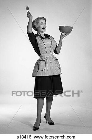 1950 1950S Woman In Apron Holding Mixing Bowl And Spoon Exaggerated Expression View Large Photo Image Stock Photograph - 1950 1950S Woman In Apron Holding Mixing Bowl And Spoon Exaggerated Expression . Fotosearch