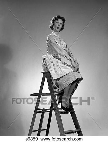 Stock Photo - 1950 1950S Woman In Apron Sitting On Ladder With Exaggerated Expression . Fotosearch