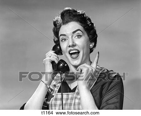 1950 1950S Woman In Apron Talking On Telephone Pointing Finger View Large Photo Image Picture - 1950 1950S Woman In Apron Talking On Telephone Pointing Finger . Fotosearch