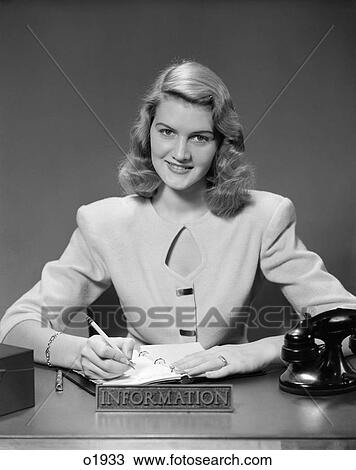 1950 1950S Woman Sitting At Information Desk In Office Writing In Book View Large Photo Image Stock Image - 1950 1950S Woman Sitting At Information Desk In Office Writing In Book . Fotosearch