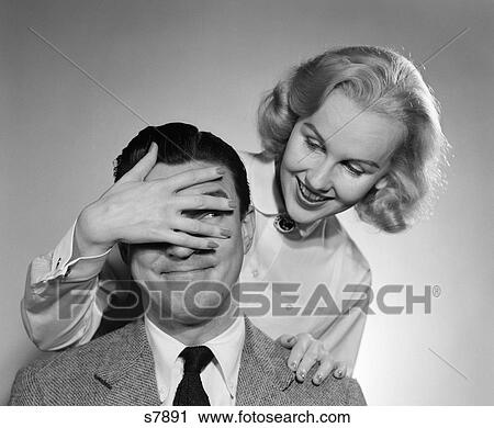 1950 1950S Woman Standing Behind Man With Hand Over His Eyes. View Large Photo Image Stock Image - 1950 1950S Woman Standing Behind Man With Hand Over His Eyes. . Fotosearch