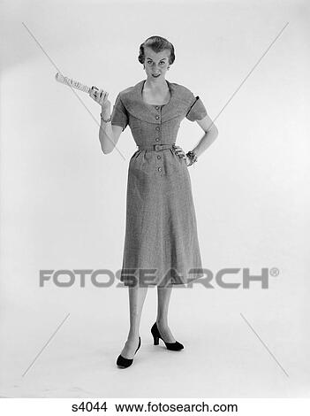 1950 1950S Woman Standing With Hand On Hip Holding Paper View Large Photo Image Picture - 1950 1950S Woman Standing With Hand On Hip Holding Paper . Fotosearch