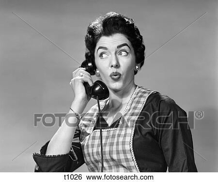 1950 1950S Woman Wearing Apron Talking On Telephone With Exaggerated Surprised Expression View Large Photo Image Stock Photograph - 1950 1950S Woman Wearing Apron Talking On Telephone With Exaggerated Surprised Expression . Fotosearch