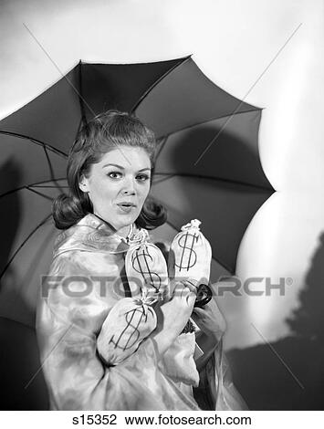 Stock Image - 1950 1950S Woman With Umbrella Holding Bags Of Money Save Your Money For A Rainy Day . Fotosearch