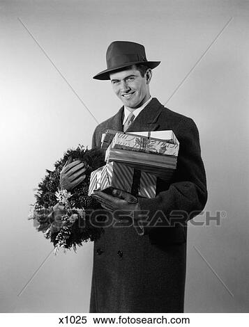 1950 1950S Young Man In Hat Coat And Gloves Holding Wreath And Wrapped Gifts View Large Photo Image Stock Photography - 1950 1950S Young Man In Hat Coat And Gloves Holding Wreath And Wrapped Gifts . Fotosearch