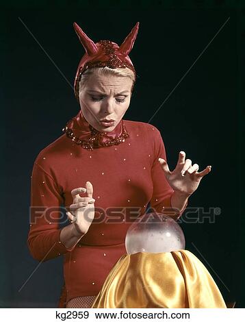 1950S 1960S 1870S Retro Woman In Red Devil Costume With Horns Looking Surprised At A Crystal Ball View Large Photo Image Stock Photo - 1950S 1960S 1870S Retro Woman In Red Devil Costume With Horns Looking Surprised At A Crystal Ball. Fotosearch