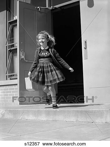 1950S 1960S Blonde Girl Running Out Front Door Of School Building Holding Lunch Box Or Book Bag Plaid Dress Sweater Smiling View Large Photo Image Stock Photo - 1950S 1960S Blonde Girl Running Out Front Door Of School Building Holding Lunch Box Or Book Bag Plaid Dress Sweater Smiling. Fotosearch