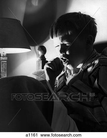 Stock Image - 1950S 1960S Boy Bed Cold Night Coughing Sneezing Cough . Fotosearch