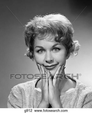 Stock Image - 1950S 1960S Happy Bemused Woman Facial Expression Both Hands To Chin Smile . Fotosearch