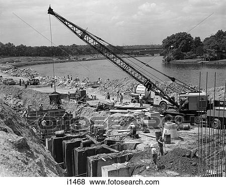 1950S 1960S Highway Bridge Construction By Side Of River Workers Men Crane Cement Forms Heavy Machinery View Large Photo Image Stock Photo - 1950S 1960S Highway Bridge Construction By Side Of River Workers Men Crane Cement Forms Heavy Machinery . Fotosearch