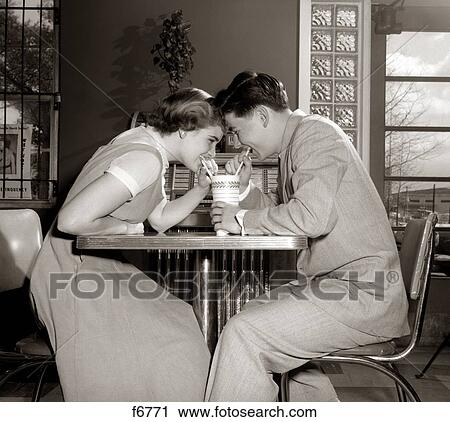 1950S 1960S Laughing Teenage Boy & Girl Sharing Drink Together With Two Straws In Soda Shop View Large Photo Image Stock Image - 1950S 1960S Laughing Teenage Boy & Girl Sharing Drink Together With Two Straws In Soda Shop . Fotosearch