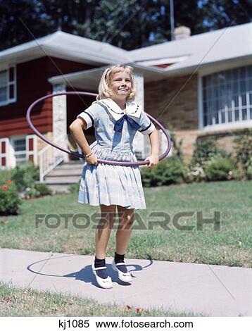 1950S 1960S Little Girl With Hula Hoop Playing Outside Laughing Purple On Suburban Sidewalk In Sailor Dress View Large Photo Image Stock Photography - 1950S 1960S Little Girl With Hula Hoop Playing Outside Laughing Purple On Suburban Sidewalk In Sailor Dress . Fotosearch