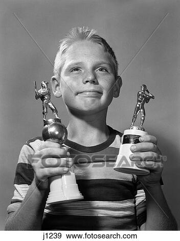 1950S 1960S Proud Boy Holding Two Awards Baseball Little League Trophies Trophy View Large Photo Image Stock Photo - 1950S 1960S Proud Boy Holding Two Awards Baseball Little League Trophies Trophy . Fotosearch