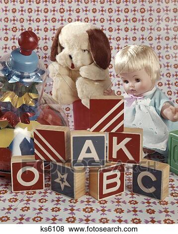 1950S 1960S Retro Tabletop Set-Up Of Toys Alphabet Wood Blocks Spinning Top Baby Girl Doll Soft Stuffed Puppy Dog View Large Photo Image Stock Photo - 1950S 1960S Retro Tabletop Set-Up Of Toys Alphabet Wood Blocks Spinning Top Baby Girl Doll Soft Stuffed Puppy Dog. Fotosearch