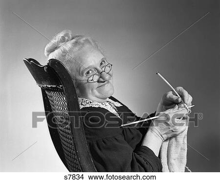 1950S 1960S Senior Elderly Woman Knitting Smiling Turning To Look At Camera Granny Glasses View Large Photo Image Picture - 1950S 1960S Senior Elderly Woman Knitting Smiling Turning To Look At Camera Granny Glasses . Fotosearch