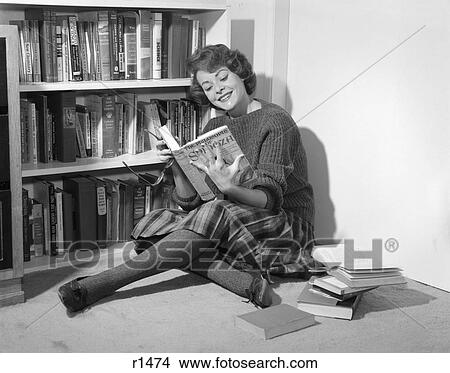 1950S 1960S Smiling Young Woman Teen Sitting On Floor By Book Shelves Reading Wearing Sweater And Plaid Pleated Skirt And Tights View Large Photo Image Picture - 1950S 1960S Smiling Young Woman Teen Sitting On Floor By Book Shelves Reading Wearing Sweater And Plaid Pleated Skirt And Tights. Fotosearch