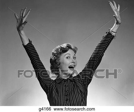 Stock Photograph - 1950S 1960S Woman Smiling Wearing A Stripe Dress Extending Her Hands & Arms Above Her Head In A Happy Ecstatic Gesture . Fotosearch